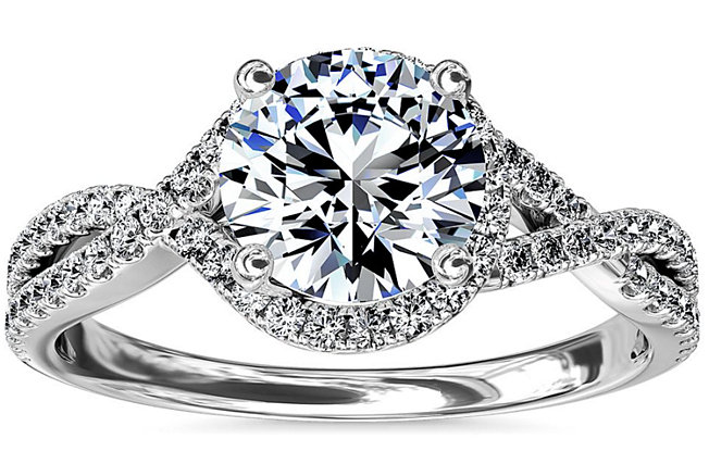 A twisted halo diamond engagement ring in 14k white gold from Blue Nile on a white background