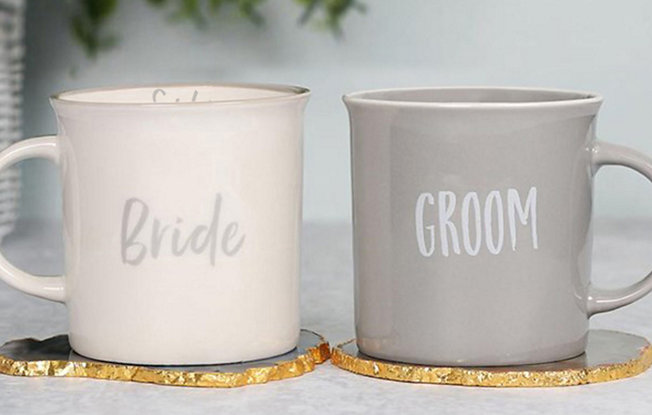 Two mugs in white and grey with the words bride and groom sit on geo coasters