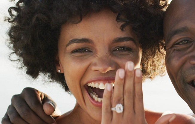 A bride displays her diamond engagement ring with her husband