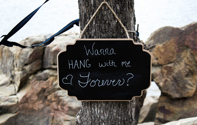 A chalkboard sign hanging from a tree