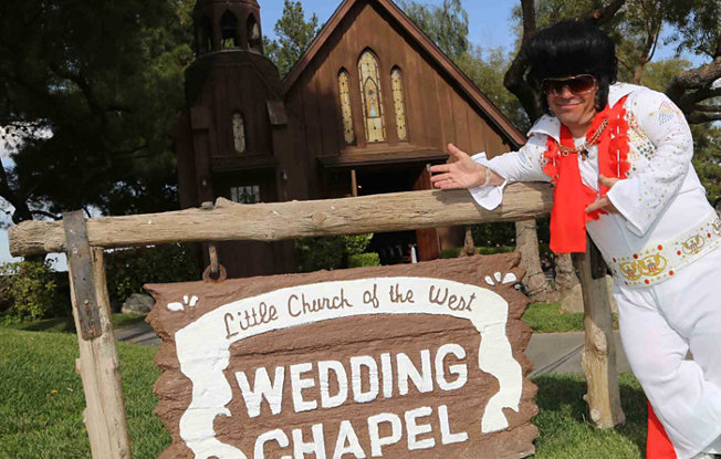 A man dressed as Elvis stands in front of the Little Church of the West in Las Vegas
